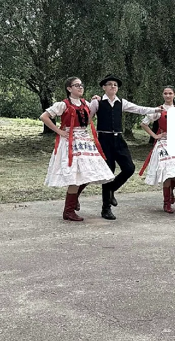 A Fergeteges táncosai viseletben táncolnak a falu útján